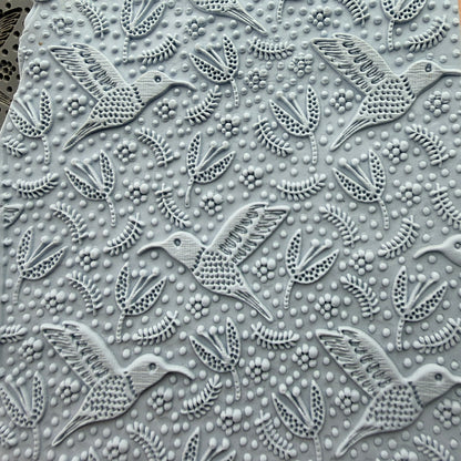 Hummingbird Flight rubber stamp impressed into polymer clay slab showing full all-over hummingbird and floral pattern